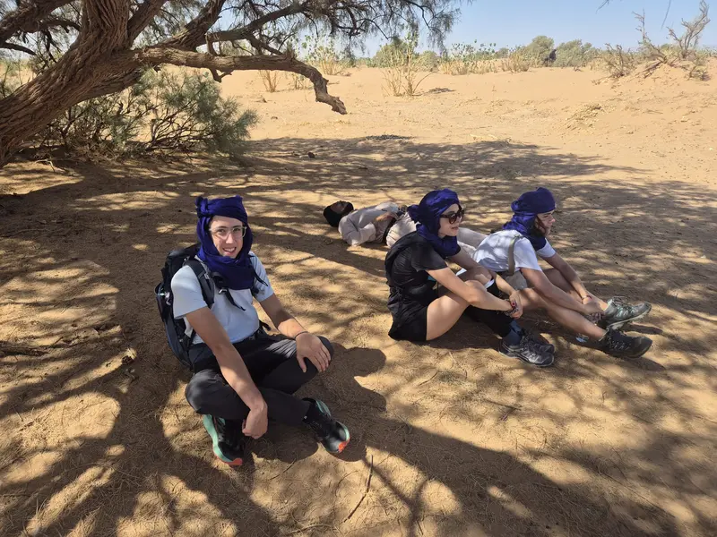Travellers in the shade of an acacia