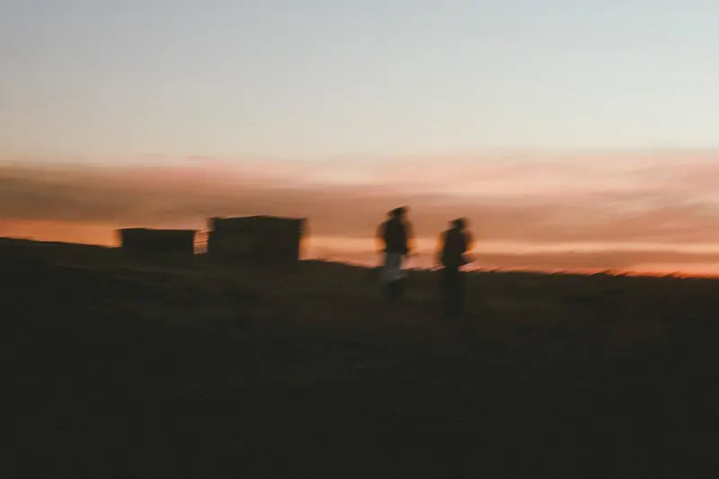 Travellers in the dunes at sunset